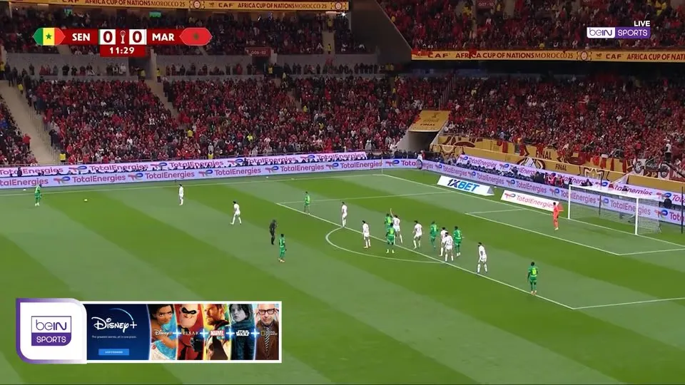 A football match with a lower-third banner ad in the bottom-left corner of the picture